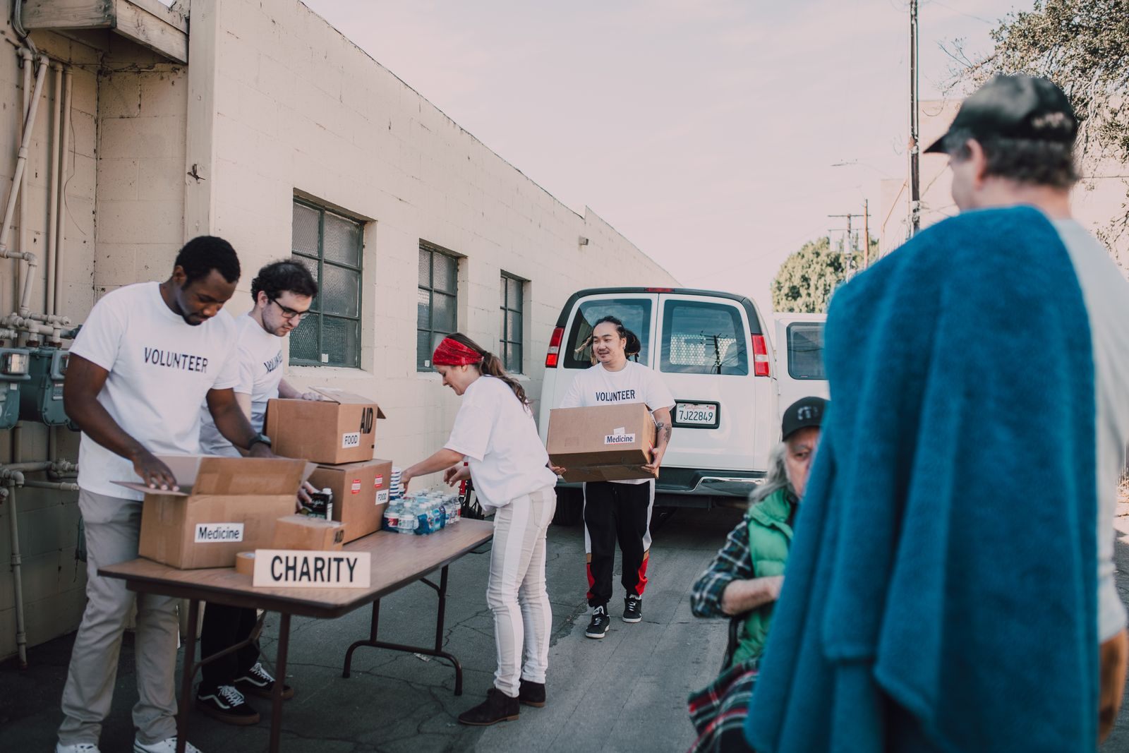 Group of volunteers organizing donations outside, showcasing diversity and teamwork